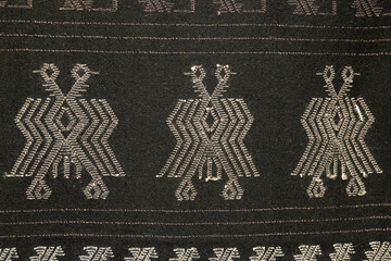 A black and white patterned cloth with three birds on it