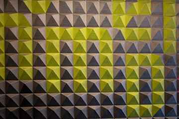 A wall with a green and gray design of triangles