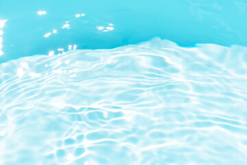 Obraz premium Blue water with ripples on the surface. Defocus blurred transparent blue colored clear calm water surface texture with splashes and bubbles. Water waves with shining pattern texture background.