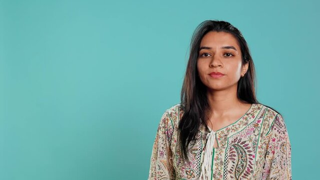 Authoritative woman doing shushing hand gesturing, demanding secrecy, irritated by noise. Stern person complaining, placing finger on lips, doing quiet warning sign gesture, studio background, camera