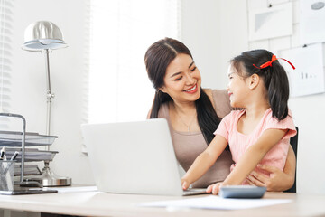 Family concept. Beautiful Mom is  taking care of her daughter while working from home.