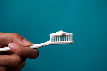 close up hand holding a brush isolated blue background