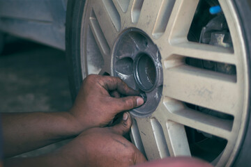 Mechanic man hands checking car tires outdoor on site service auto garage for automotive mobile...