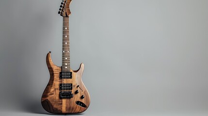 Obraz premium Solid wood electric guitar isolated upright on a grey background