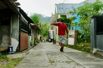 A traditional meatball soup (bakso) vendor traversing a serene village lane. Immerse yourself in the charming street food ambiance of rural scene
