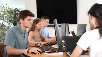 Focused guy student of computer courses types on keyboard, performs work, educational practical task