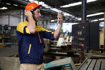 engineer or technician online video call with coworker from tablet and checking lathe machine in factory