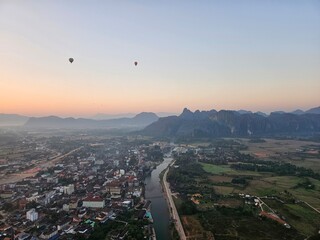Sunrise view of city and mountains while hot air ballooning in Vang Vieng, Laos 