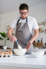 man wearing apron cooking tiramisu at kitchen