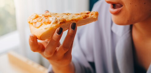 Cropped image of woman holding pizza slice at restaurant