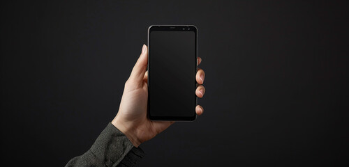 hand holding smartphone over the black background 