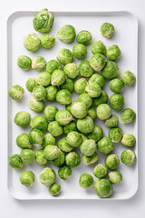 흰쟁반위에 여러개의 미니양배추가 자연스럽게 쌓여있다.