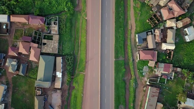Top View Of Houses Along Kampala-Entebbe Expressway With Vehicles Driving In Kampala, Uganda. aerial shot