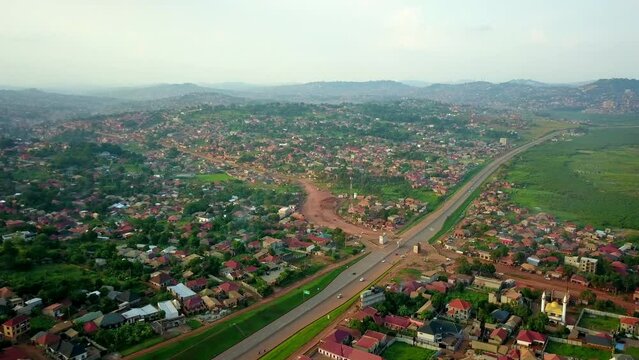 Kampala-Entebbe Expressway, Uganda, East Africa - Vehicles Traveling on the Highway Next to a Residential Community - Aerial Drone Shot