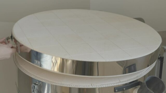 a female opening a pottery kiln