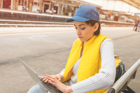 seriouse woman at railway station using computer, laptop.  Enjoying travel concept.