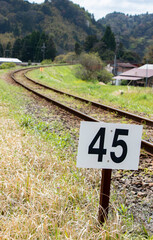 田舎を走るローカル線の単線線路と標識