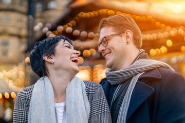 laughing  young couple falling in love hugging  having fun time  in Christmas market lifestyle...