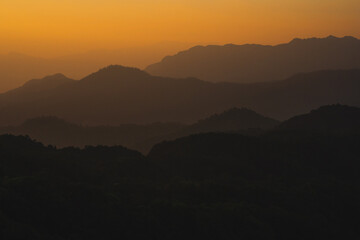 nature traveling with orange sky and layer of mountain with sunrise background