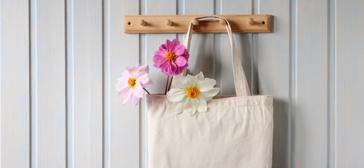 Dahlias in a cloth bag hanging on a wooden hanger, close-up. Natural background, copy space. concept without plastic .