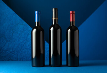 Bottles of red wine on a blue background.