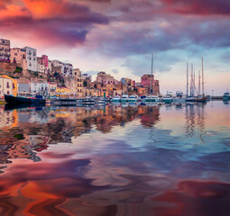 Old colorful buildings of Castellammare del Golfo port reflected in the calm water of Mediterranean...