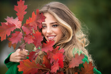 Autumn fall. Portrait young woman with autumn leafs on foliage. Beautiful girl outdoor in autumn. Sensual woman with yellow leaves in autumn. Pretty woman with leaf near face on autumnal background.