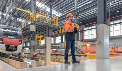 Fototapeta premium Engineer reviews data, updates train maintenance, and ensures safety for quality rail service.