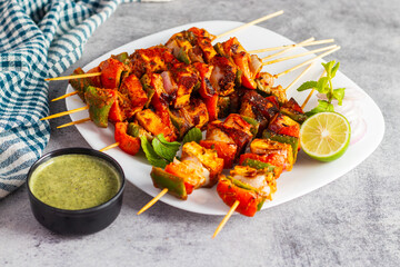 selective focus of famous Indian dish Paneer Tikka Masala Tandoor or Paneer Kebab with a dark background.