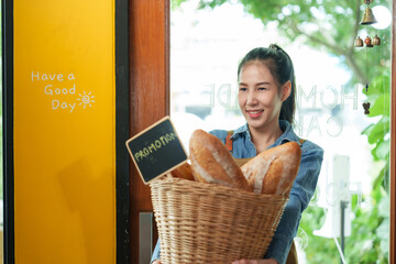 Welcoming Asian bakery staff with a basket full of fresh bread, exemplifying small business charm. happiness of opening a coffee shop in the morning small family business.