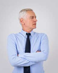 Portrait of a grey haired businessman standing against isolated background