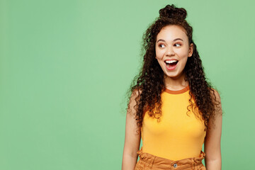 Young surprised shocked fun woman of African American ethnicity wear yellow tank shirt top look...