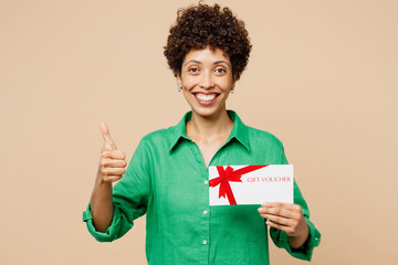 Young woman of African American ethnicity wear green shirt casual clothes hold gift certificate...