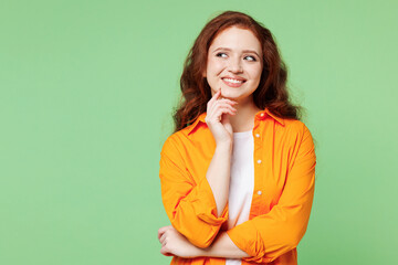 Young fun ginger woman she wear orange shirt white t-shirt casual clothes put hand prop up on chin,...