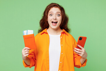 Traveler shocked woman wear orange casual clothes hold passport ticket use mobile cell phone...