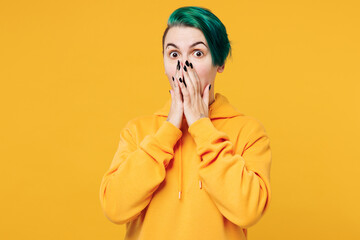 Young shocked surprised happy woman with dyed green hair wearing hoody casual clothes cover mouth...