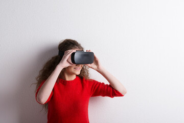 Young teenage girl with VR headset. Virutal reality, VR technology. Studio shot on white background...