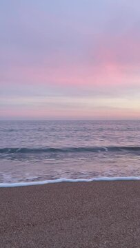 4k video of the sunset on the beach with the pink sky. Video in vertical format.