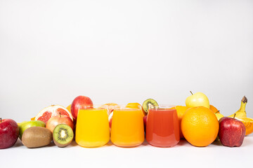 Different fruit juices in glasses on white background with space for text