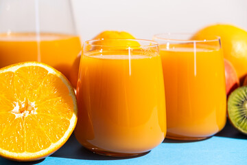 Multi-fruit juices in glasses among fresh fruits.