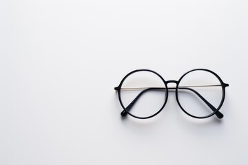 Minimalistic composition of round black eyeglasses on white background