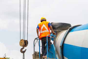 Worker man on concrete mixer trucks at construction site