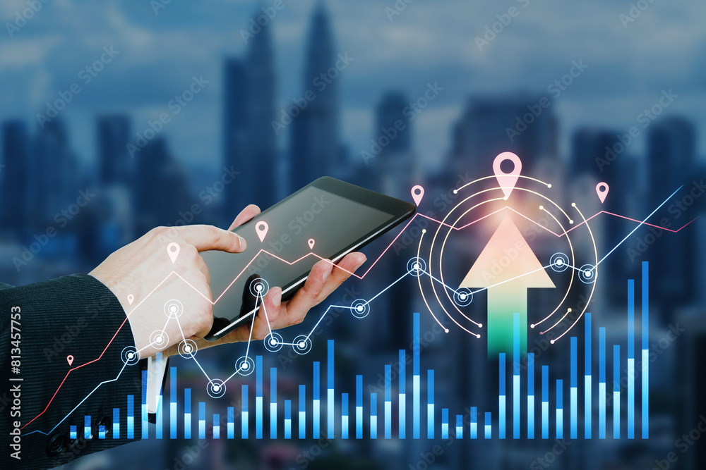 Poster close up of businessman hand using pad with growing forex chart with arrow on blurry city background