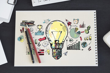 Hand-drawn light bulb with business and creativity icons on spiral notebook, wooden desk...