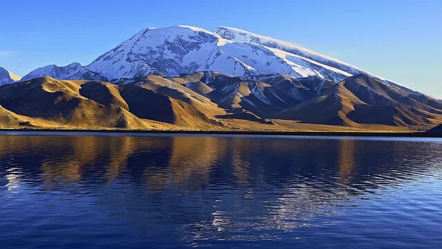 The reflection of Kalkul Lake beneath the snow-capped Muztagh Ata on the Pamir Plateau in Xinjiang, China