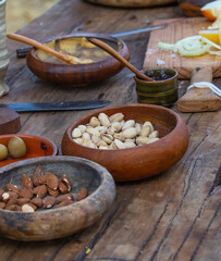 Ceramic bowl with nuts, almonds and pistachios, close-up, ceramics on a wooden table, focus on one bowl, still life