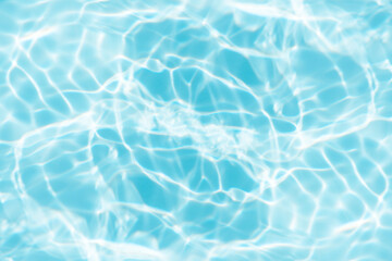 Blue water with ripples on the surface. Defocus blurred transparent blue colored clear calm water surface texture with splashes and bubbles. Water waves with shining pattern texture background.