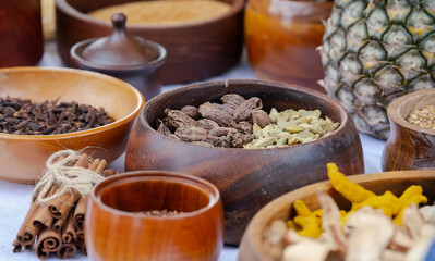Wooden bowls with spices, cinnamon, cardamom, cloves, nutmeg, close up, ceramics on a wooden table, still life