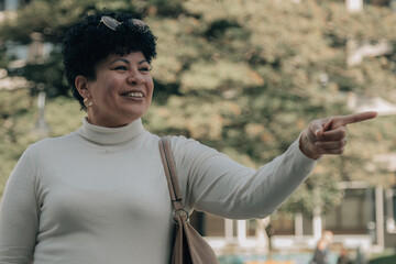 mature woman pointing her finger in a direction on the street