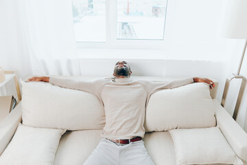 Relaxed African American Man Sitting on Sofa at Home, Smiling and Enjoying a Weekend of Rest and Comfort